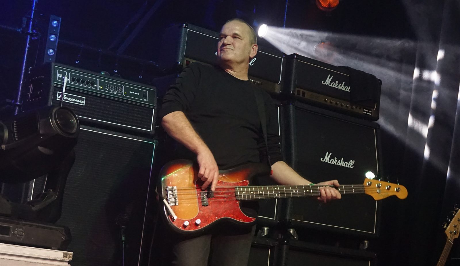 Black Knight bassist on stage in front of a wall of amplifiers