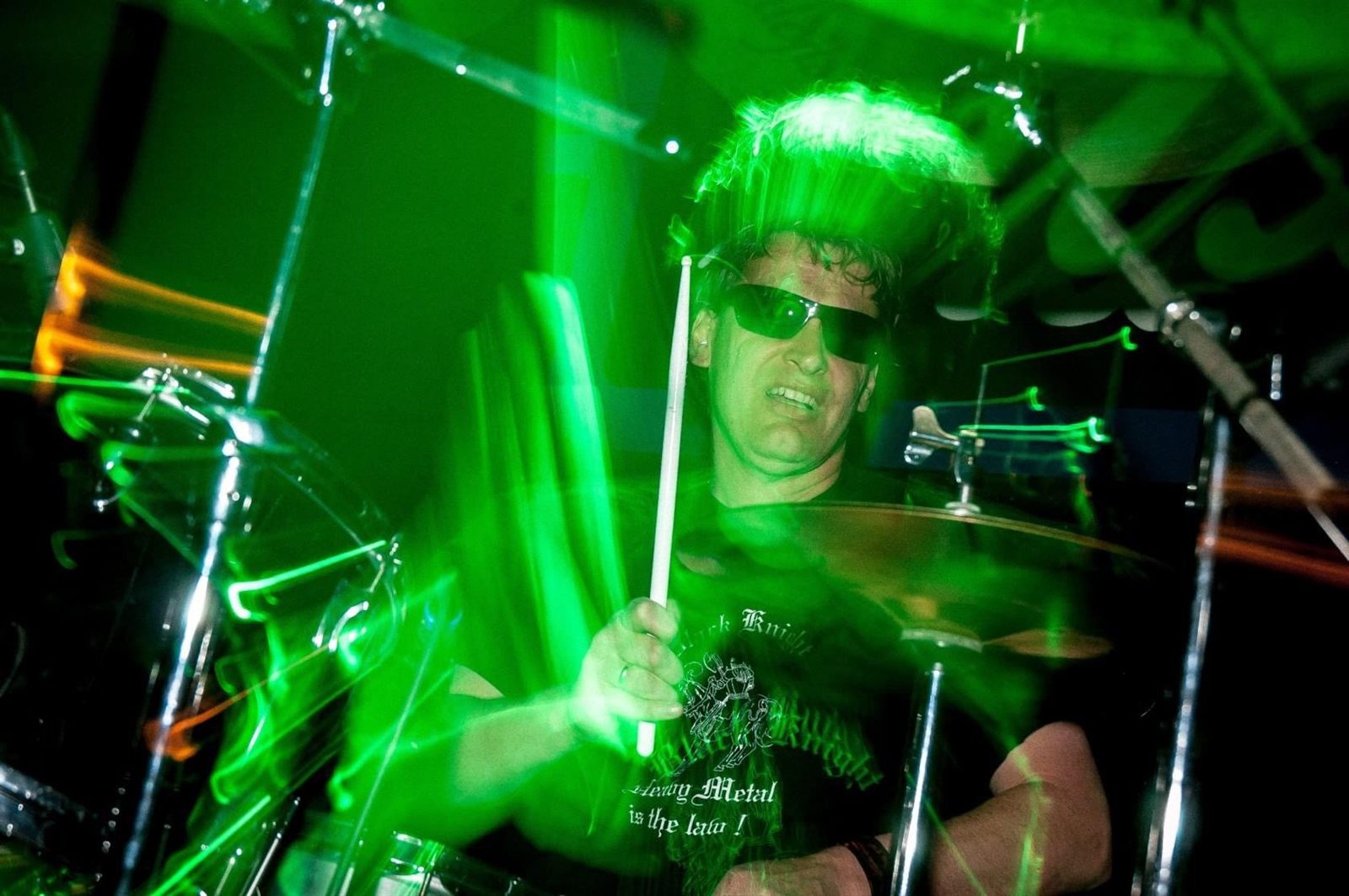 Black Knight drummer in motion under green stage light