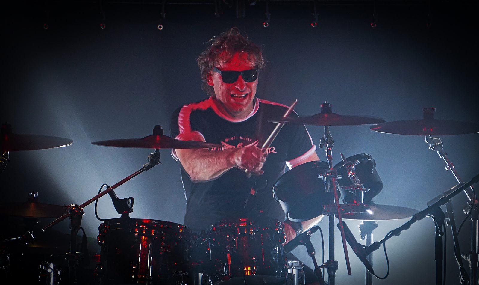 Black Knight drummer behind the kit in red stage light